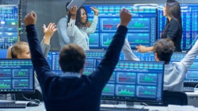 Wall Street traders looking at graphs and charts cheering because the stock market went up
